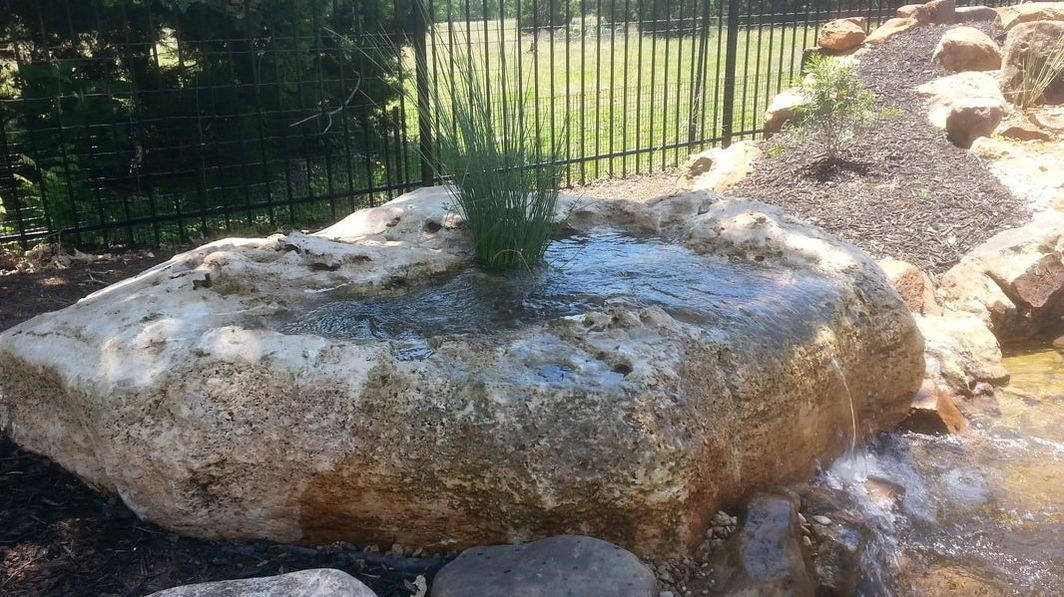 Natural Bubbling Rock Fountain that Spills into a Backyard Koi Pond near Austin in Central Texas